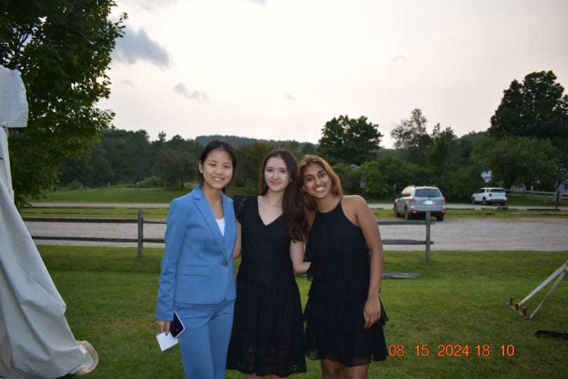 Three Senators in formalwear on the lawn beside an event tent in the evening light at Plymouth Notch.