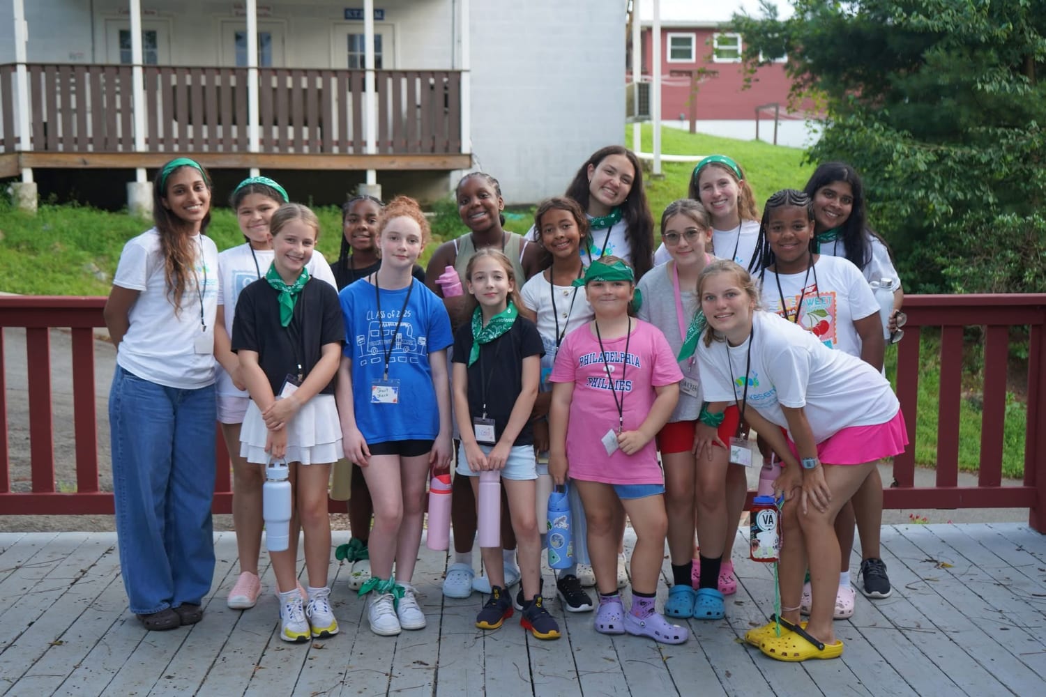A cabin of campers and their counselors gathered on the wooden deck outside the bunks, everyone in green Kesem bandanas.