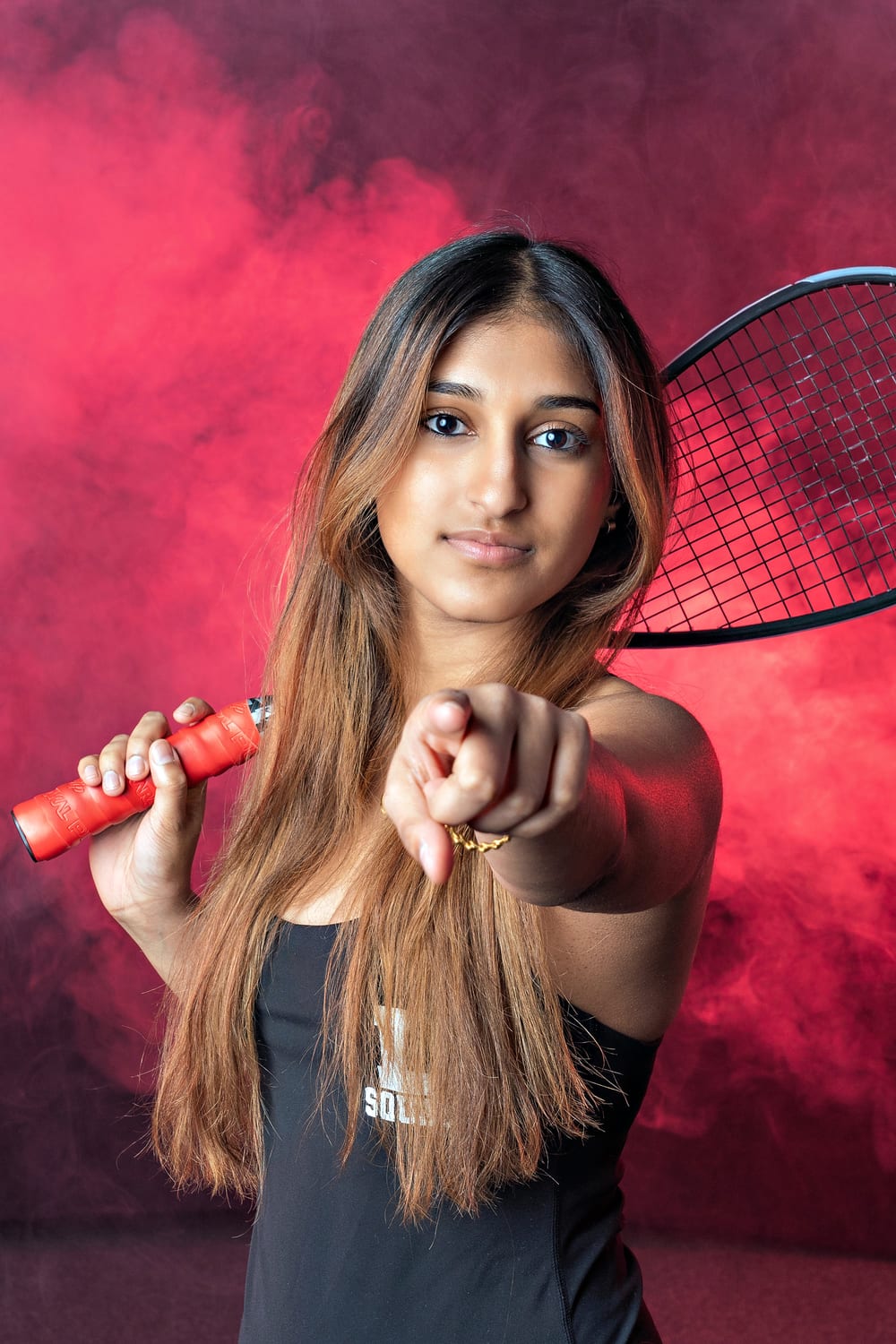 Studio squash portrait of Ava with her racket
