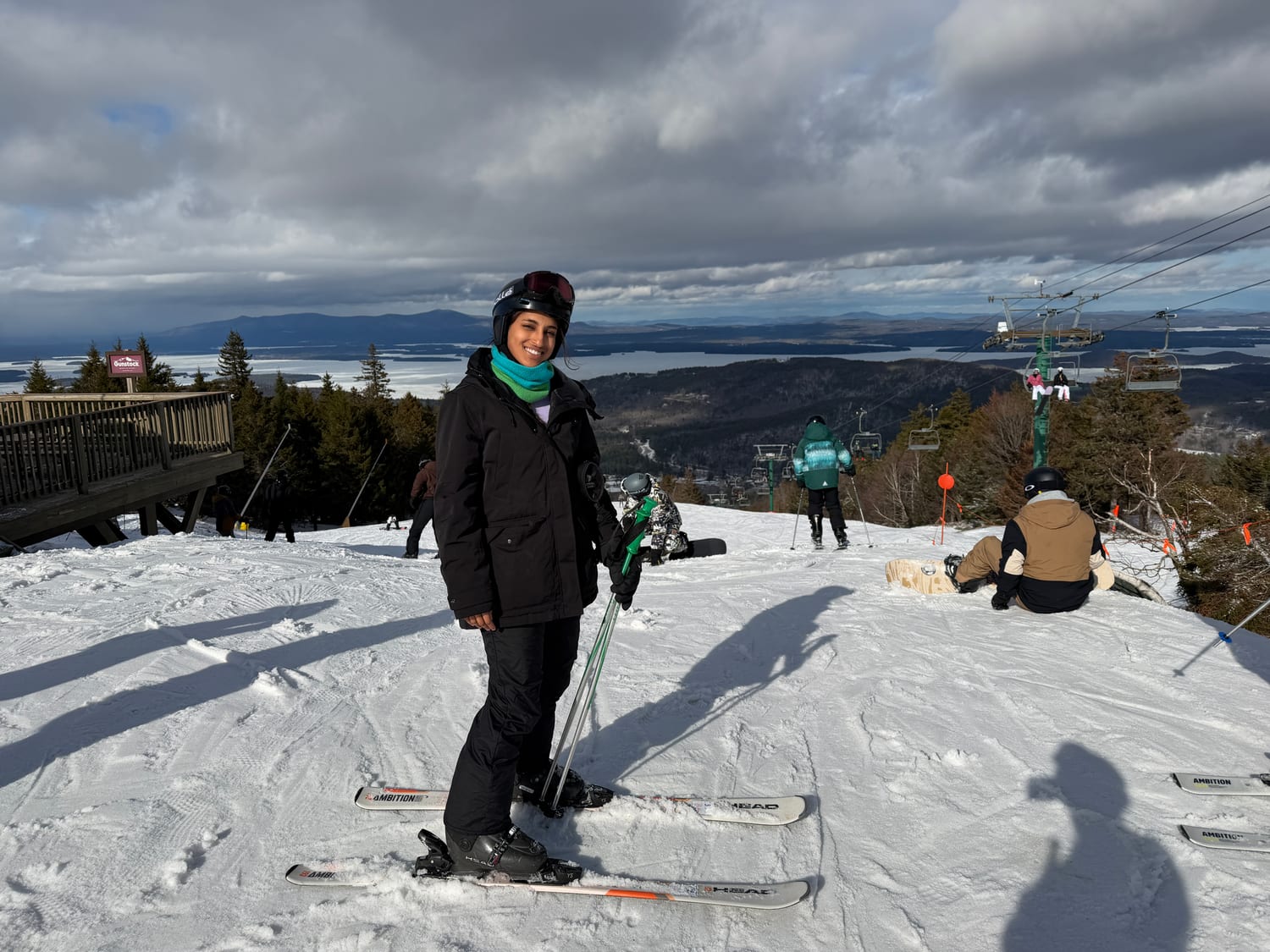 Ava skiing at the top of a run above a frozen lake