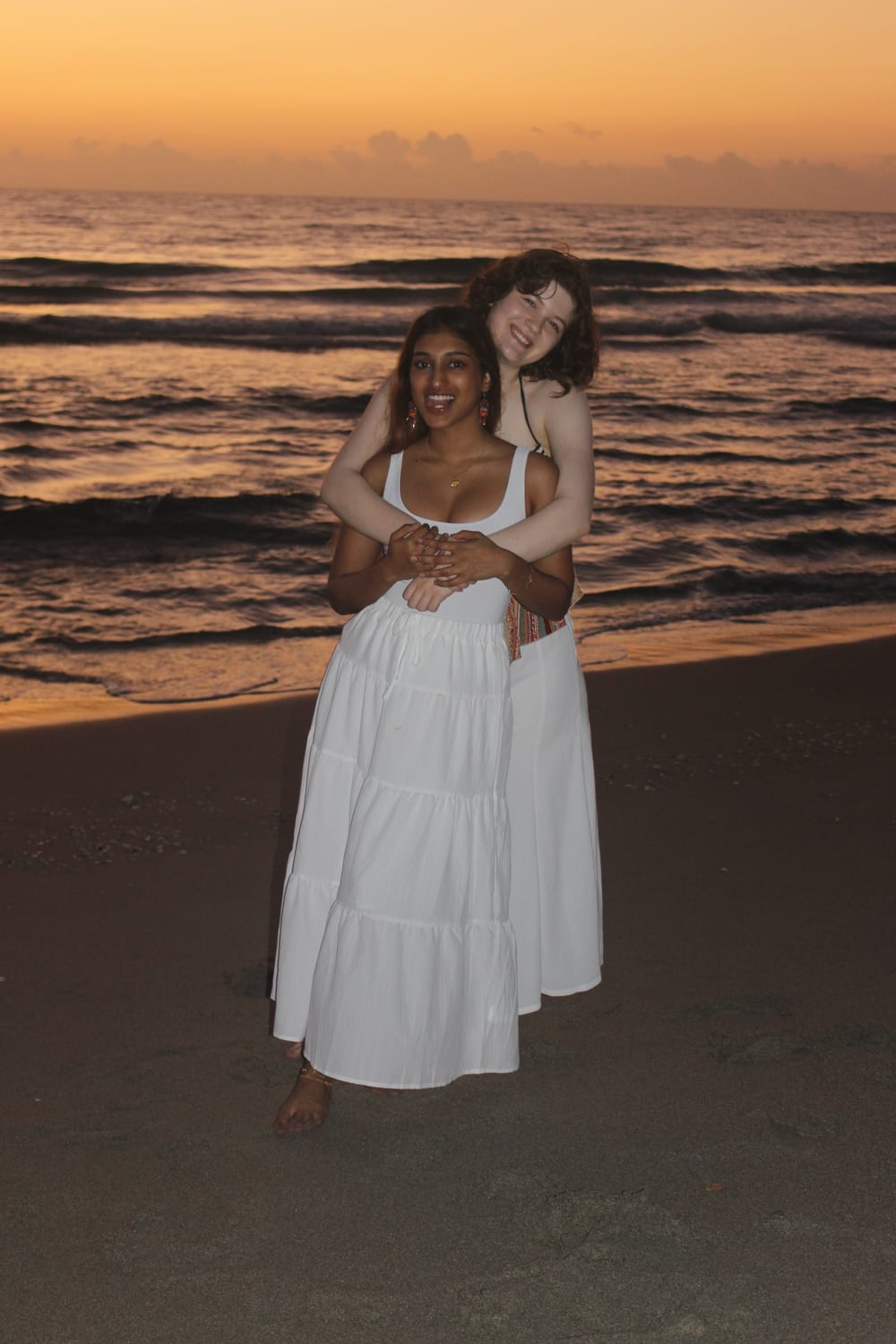 Ava and a friend on the beach at sunset