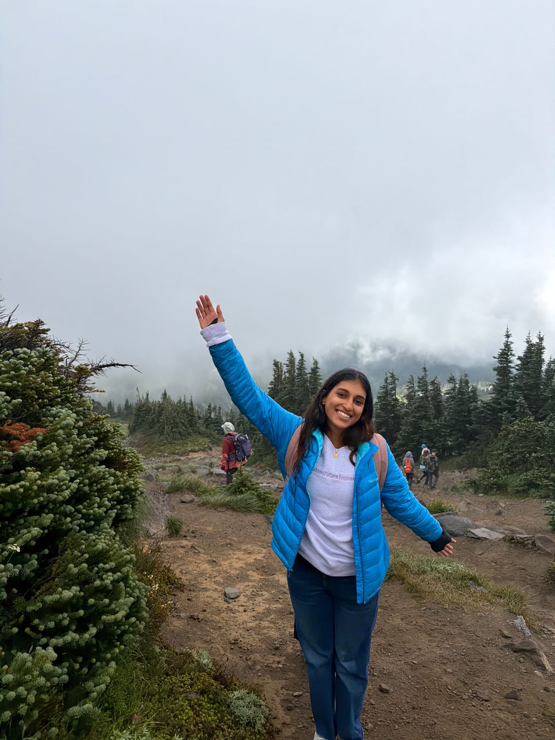 Ava hiking a foggy trail in an Amazon Future Engineer hoodie