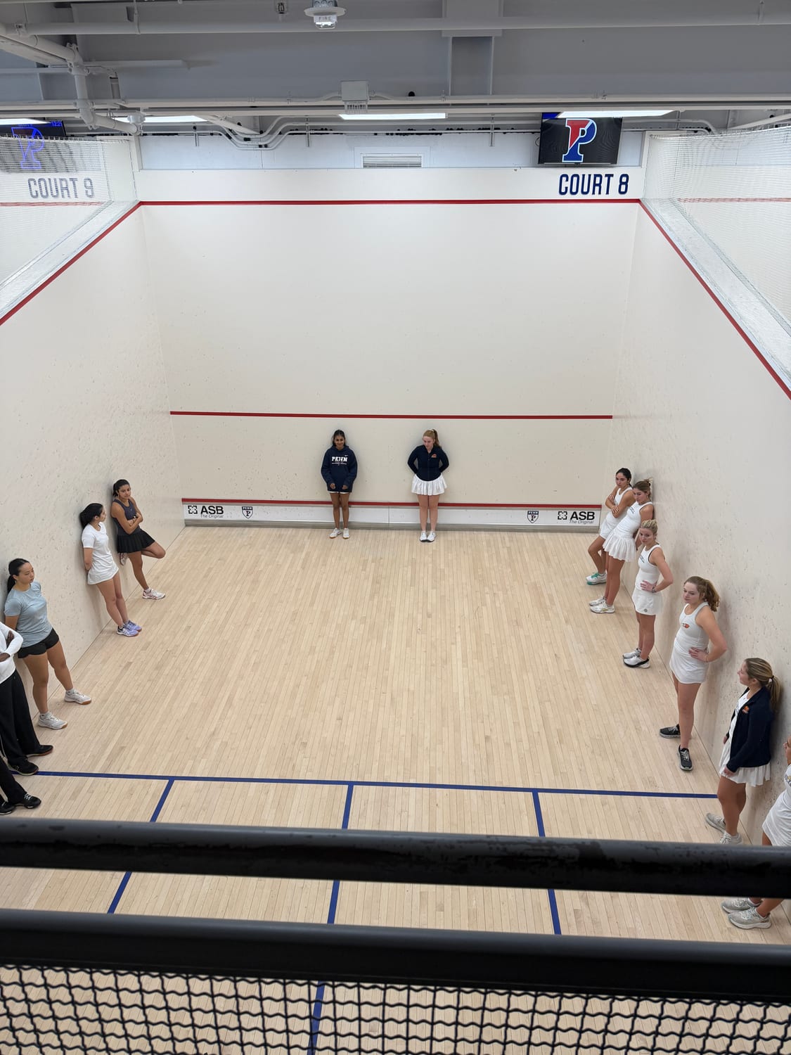 Overhead view of Ava's squash team lining up before a match at Penn