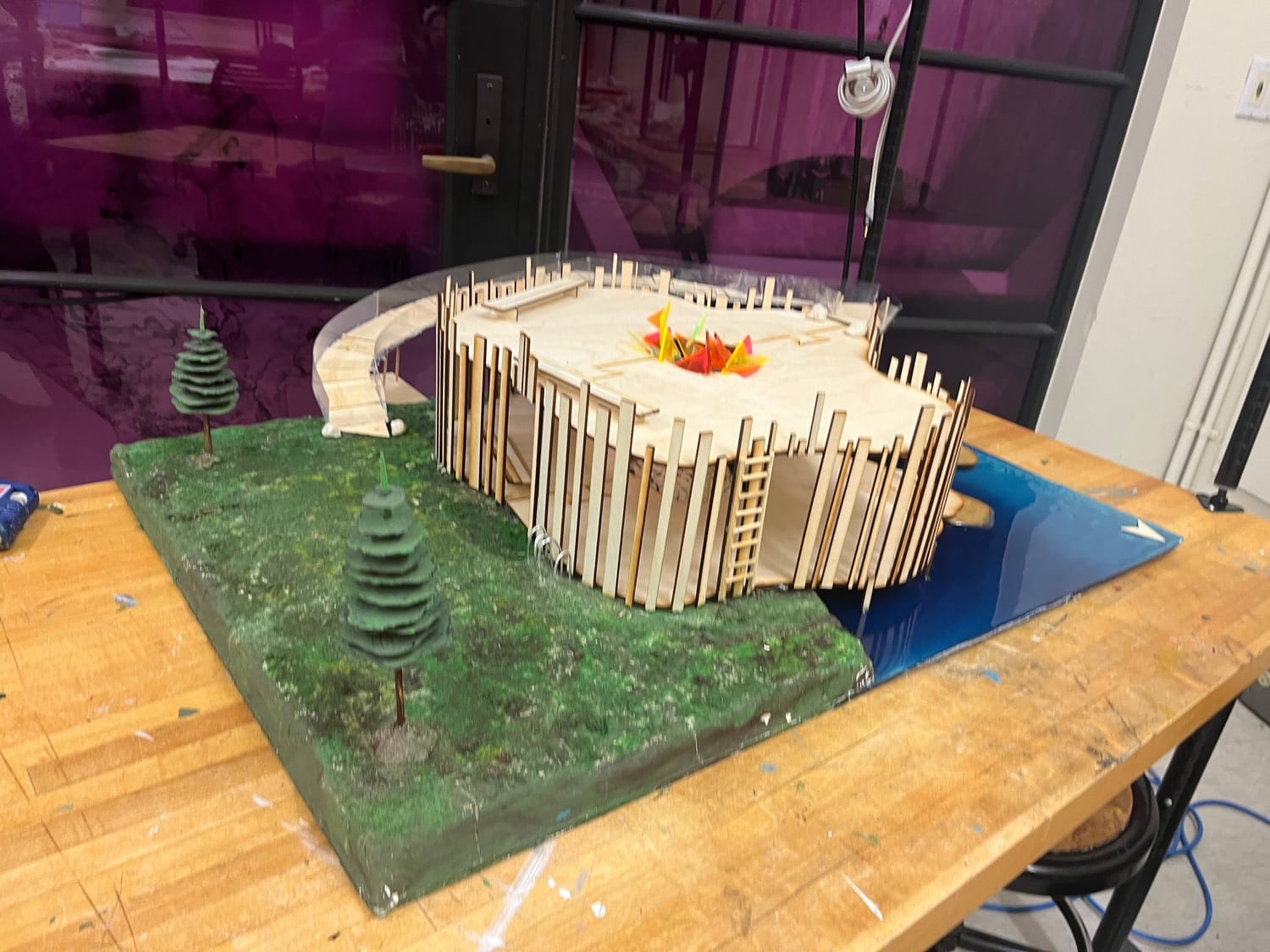The model on its green terrain base with modeled conifers, the curved ramp sweeping in from the left.