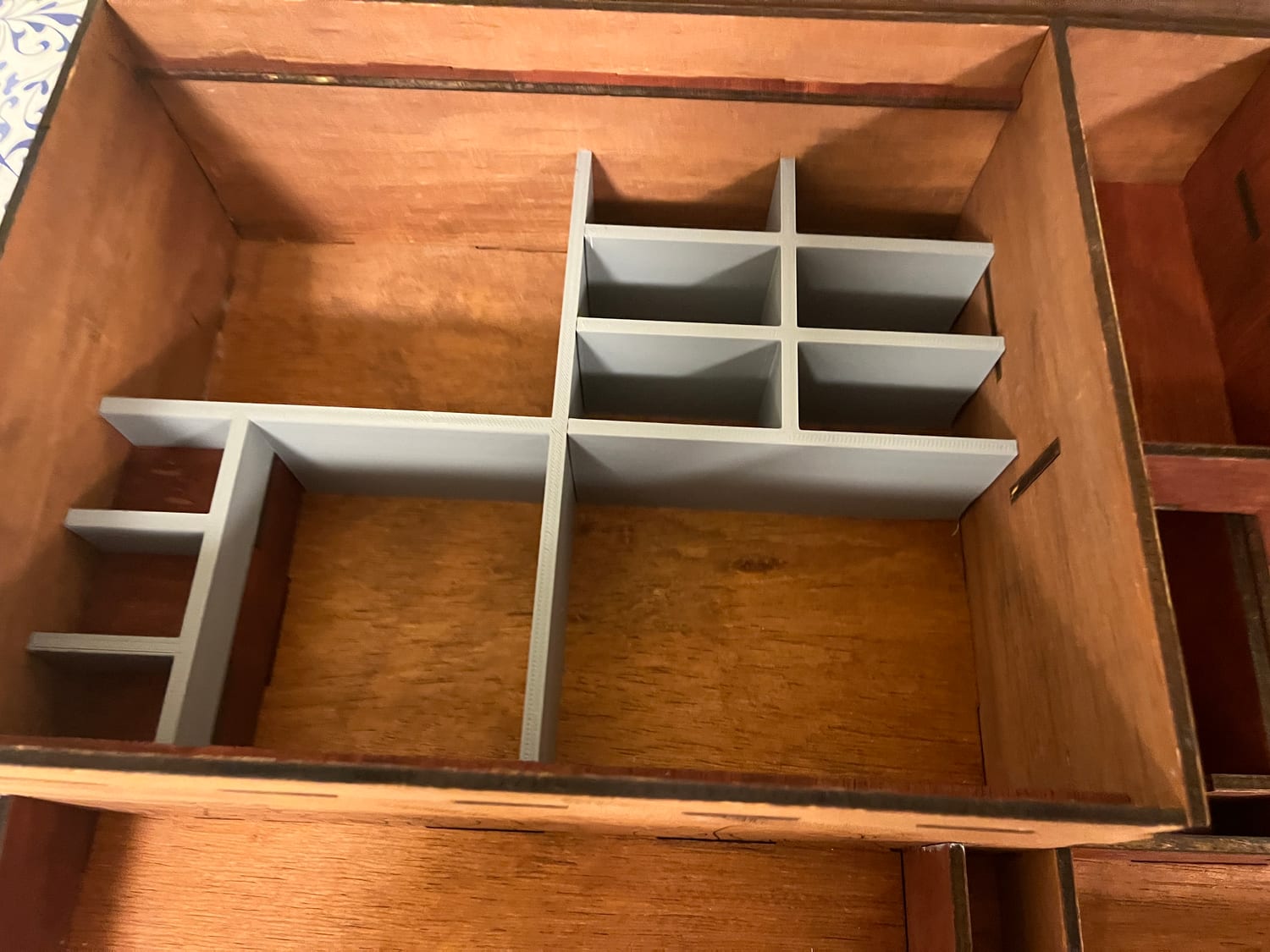 The 3D-printed insert on its own: an L-shaped grid of cells I modeled to drop into the jewelry bay.