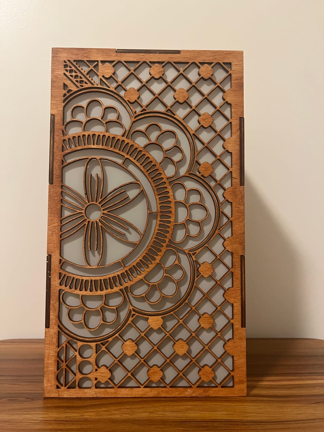 A fourth face, mandala-led: a six-petal rosette in concentric scalloped rings over a quatrefoil lattice.
