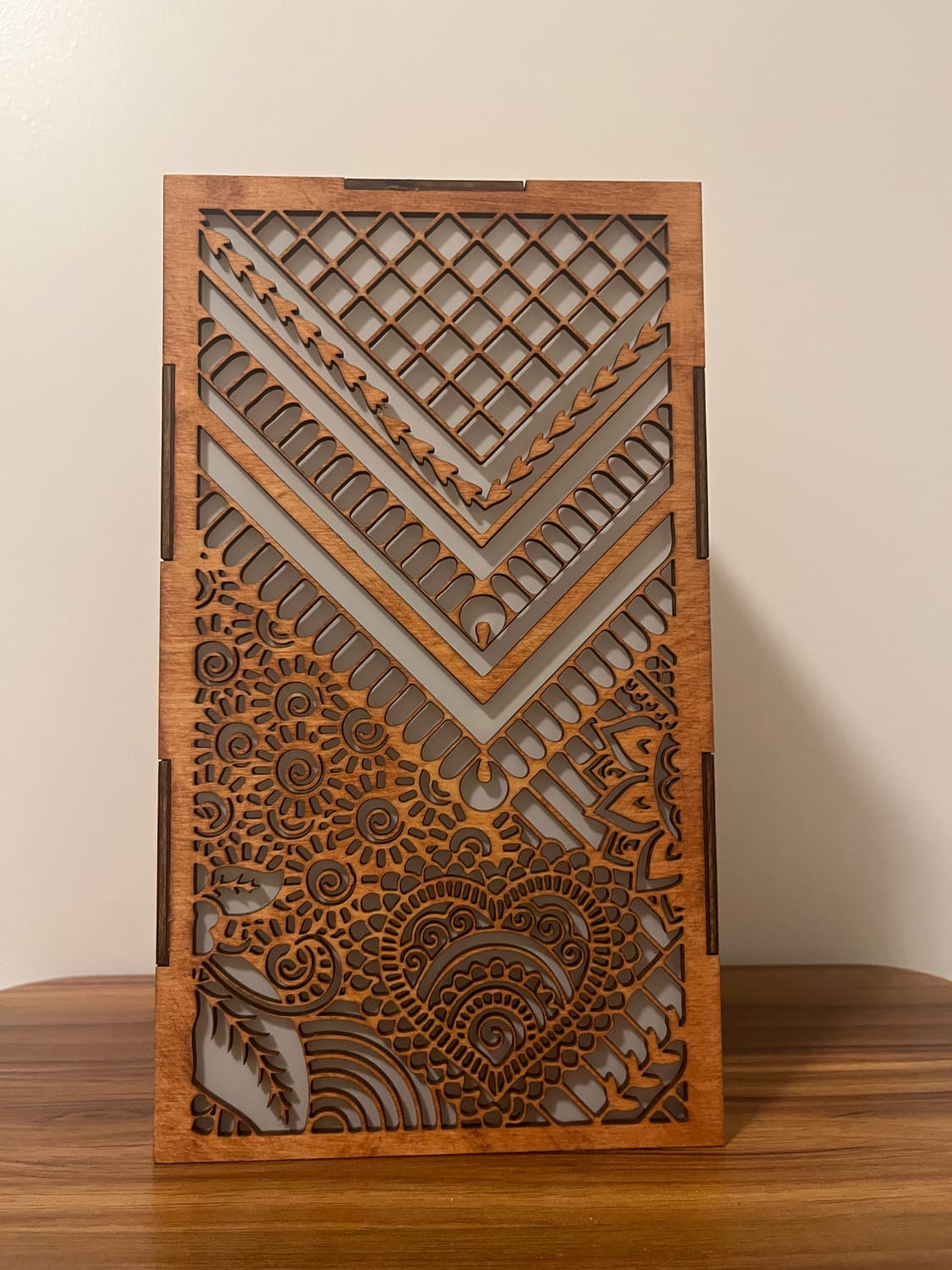 A third face: nested chevron borders over a dense field of henna paisley, hearts and spirals.