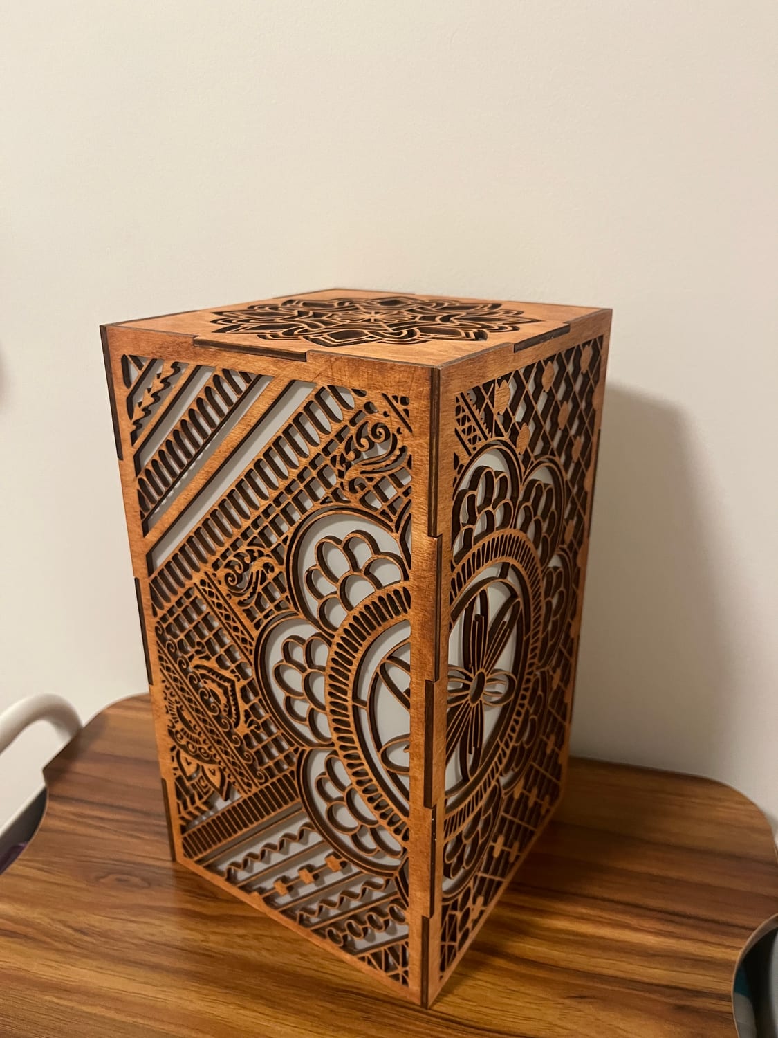 Looking down at the finished box: four fretwork walls meeting in finger-jointed corners, capped by a removable lid with its own mandala.