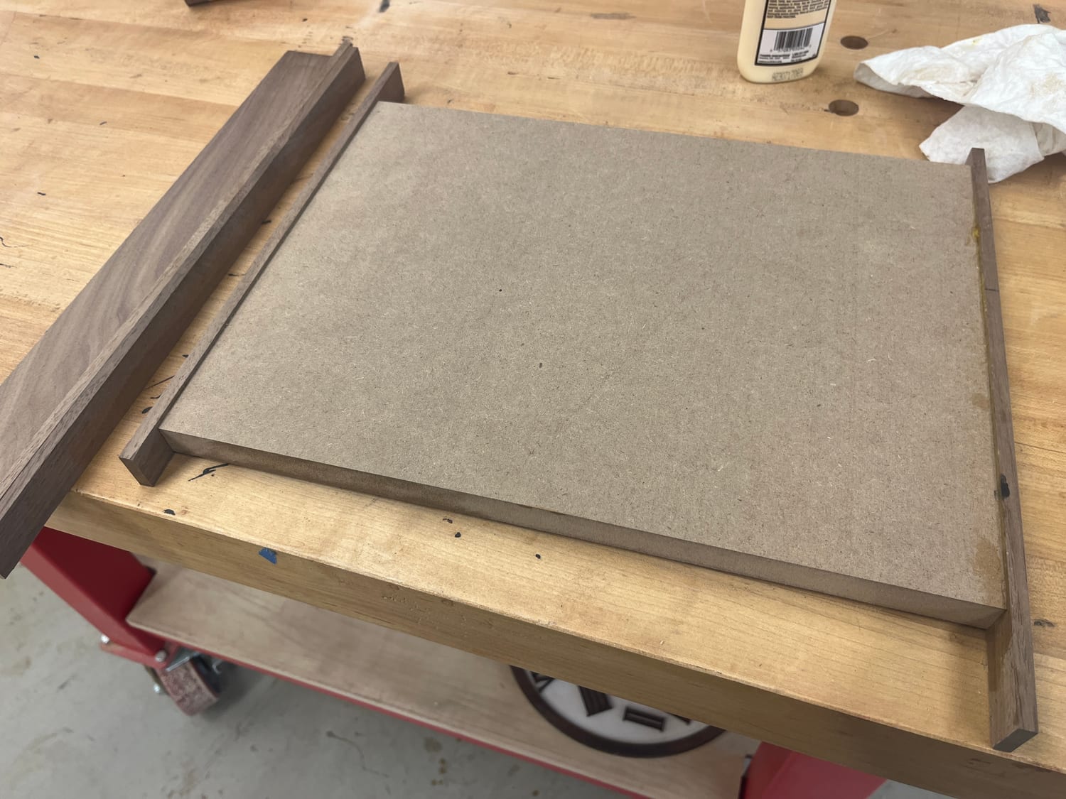 The MDF substrate on the bench with its solid walnut edging strips waiting to go on, glue bottle at the ready.
