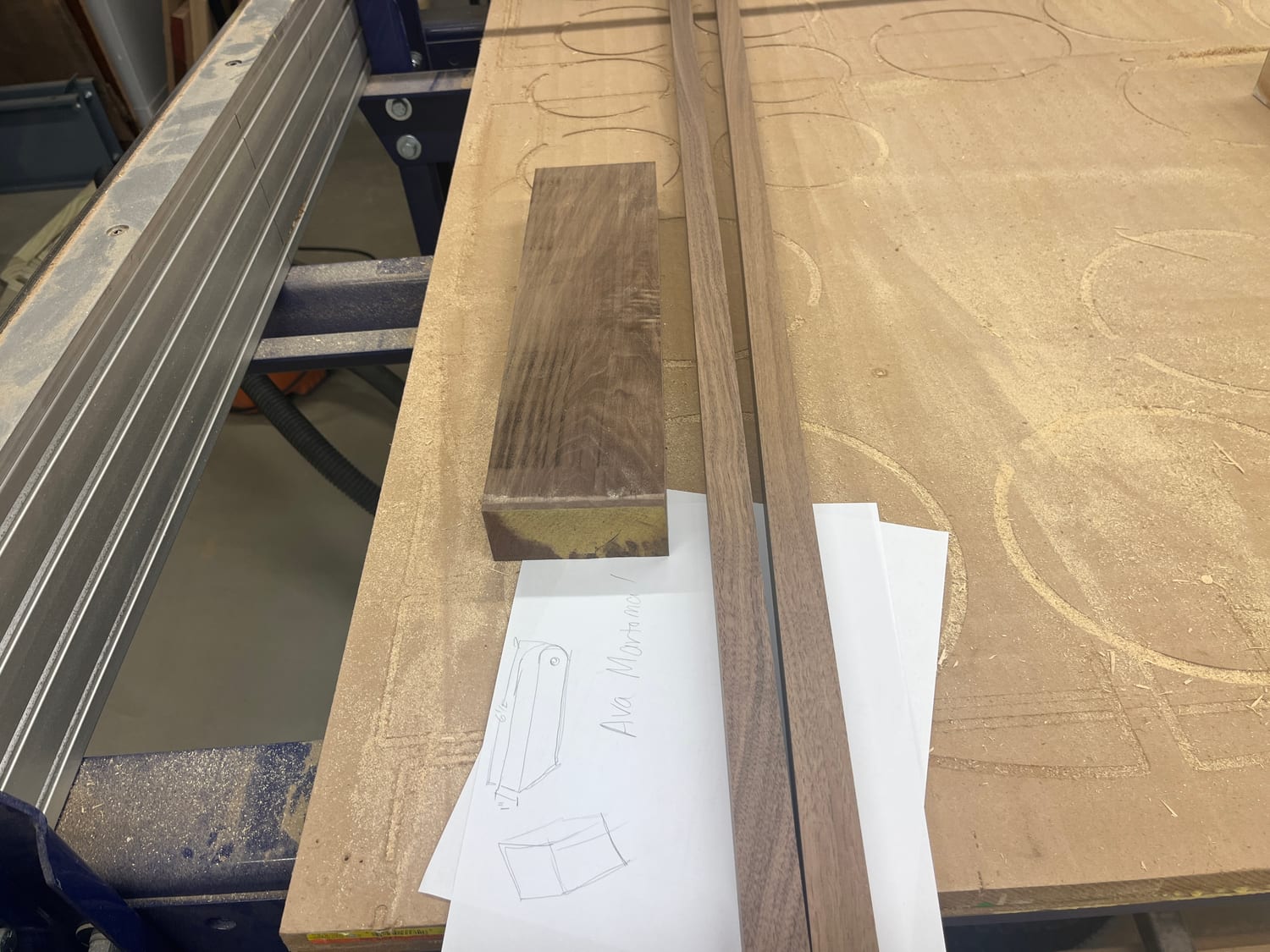 Walnut stock on the shop bed beside my hand sketch of the folding desk.