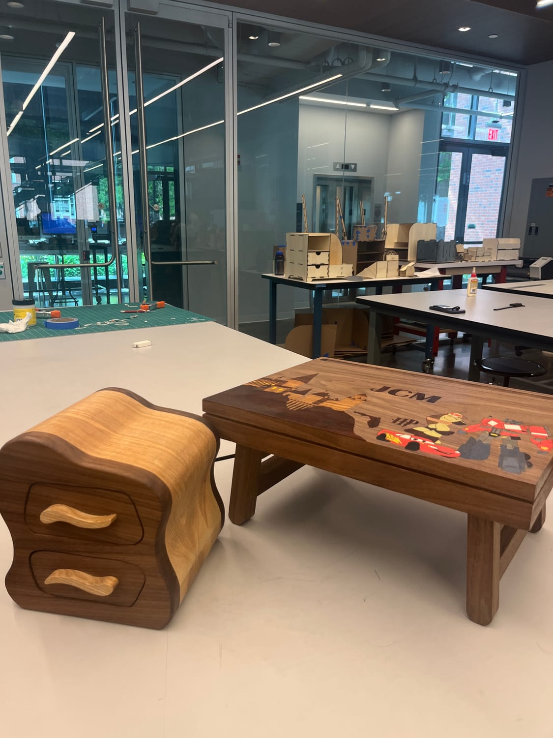 The desk on the makerspace bench beside a wavy-fronted walnut and maple drawer box.