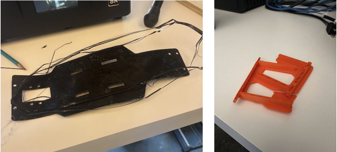 The resin-printed chassis plate (left) and an orange 3D-printed bracket (right).