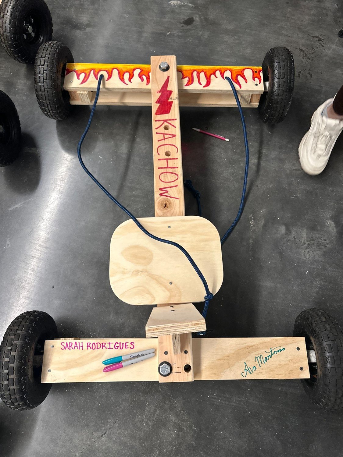 The finished car, top-down — "KACHOW", a lightning bolt, painted flames, and the team's signatures.